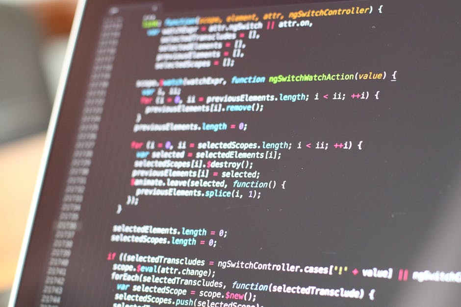 A close-up image of a computer screen displaying colored lines of programming code, set against a dark background. The code features various syntax highlighted in multiple colors, including pink, blue